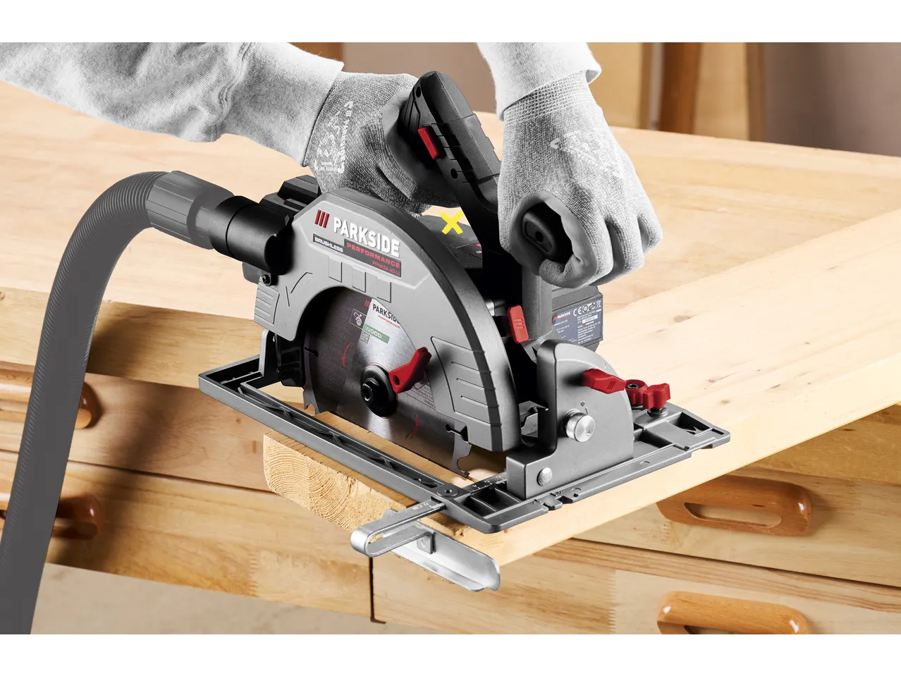 PARKSIDE PERFORMANCE PPHKSA 40-LI cordless circular saw cutting wood, with safety gloves.
