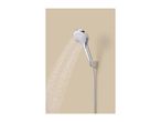 A chrome shower head spraying water, mounted on a beige wall.