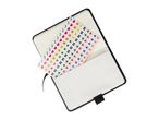 A black notebook with a sheet of emoji stickers in the pocket.