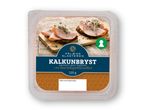 En pakke med skiver af kalkunbryst krydret med paprika, serveret på rugbrød med spirer.