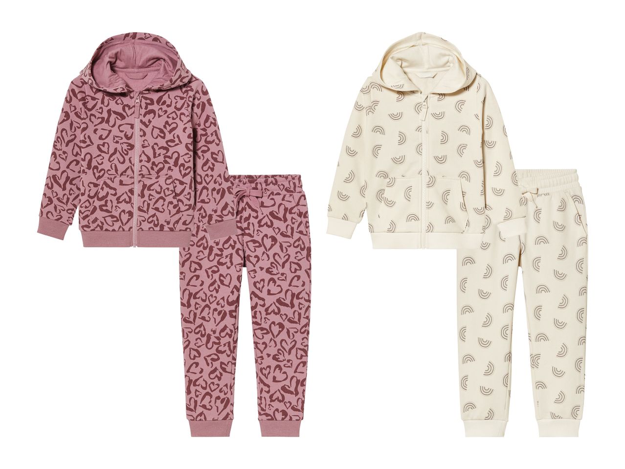 Zwei Kinder-Jogginganzüge: ein rosafarbener mit Herzen und ein cremefarbener mit Regenbögen.