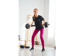 Mulher de t-shirt Crivit preta e leggings cor-de-rosa a exercitar-se com halteres.