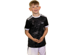 Smiling boy in a black and grey Kids' Training Jersey with white shorts.