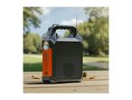 Portable power station with flashlight, USB ports, and radio antenna on a wooden table outdoors.