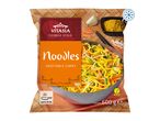 Frozen vegetable curry noodles in a bag, with a wok of noodles and ingredients on a bamboo mat.