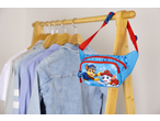 Bolsa de cintura azul da Patrulha Pata com Chase e Marshall, pendurada num bengaleiro de madeira com camisas.