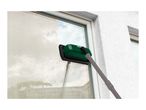 Window cleaner with an extendable pole cleaning a dirty window, showing a clean streak.