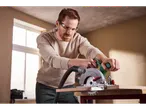 Homem a usar uma serra circular sem fios Parkside 20 V para cortar madeira.