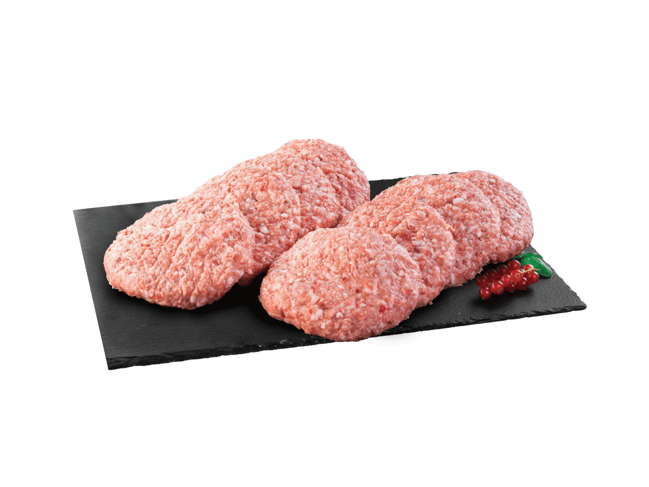 Sveže mleveno meso oblikovano u pljeskavice na crnoj dasci sa crvenim ribizlama.