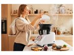 Woman using a multi-functional food processor in the kitchen.