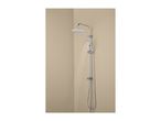 Chrome shower system with a large overhead shower and a handheld shower, water running.