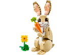A toy rabbit made of building blocks holding a carrot, with a flower nearby.