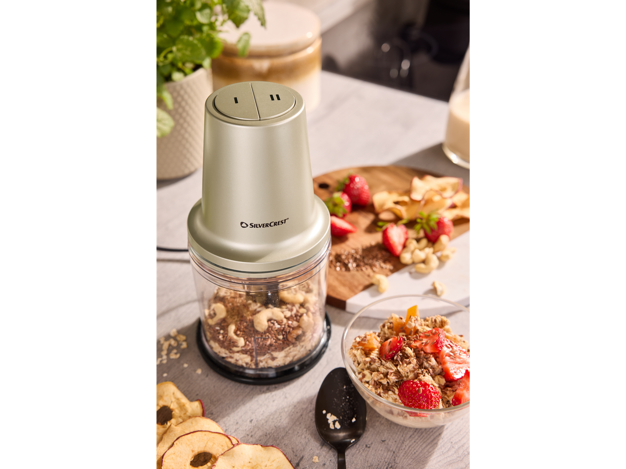 A Silvercrest mini chopper filled with nuts and oats, next to a bowl of muesli.