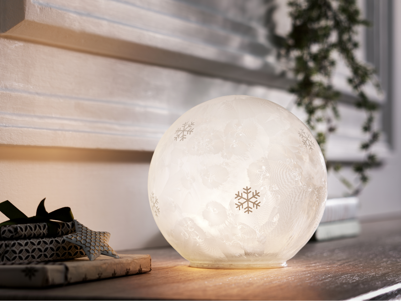 Livarno Home LED-dekoratiivvalgusti lumehelbe mustriga, pakitud kingituste kõrval.
