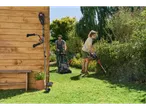 Homem a cortar relva, mulher a aparar sebe, roçadora 2-em-1 Parkside Performance®.