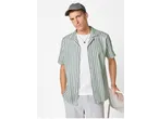 Cămașă bărbați ESMARA MEN: bărbat în cămașă cu dungi verzi și albe, tricou alb, pantaloni scurți gri și șapcă.