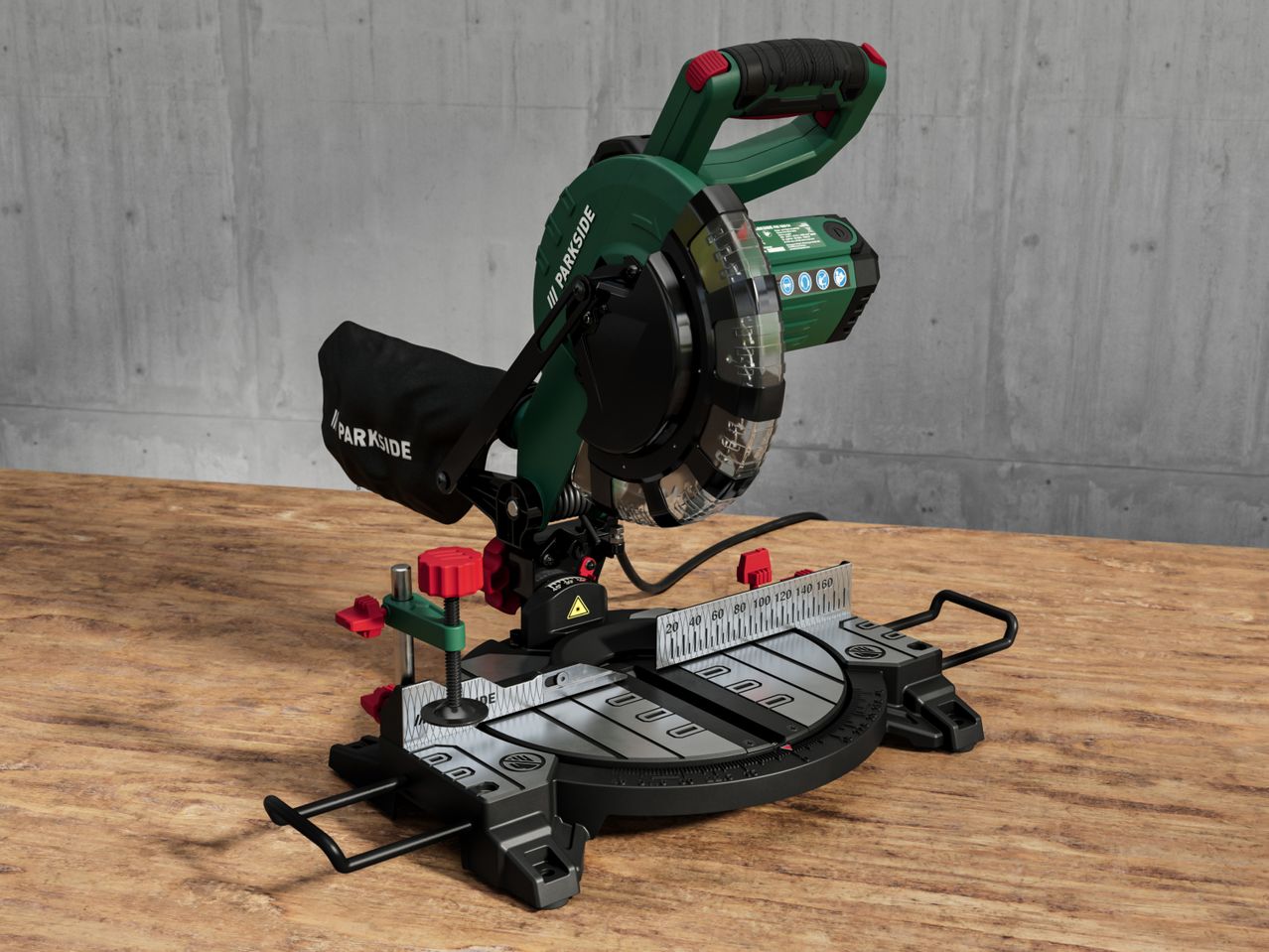 A Parkside miter saw sits on a wooden table against a concrete wall.
