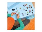 Overhead view of a child playing with various toy minifigures and accessories on a blue surface.