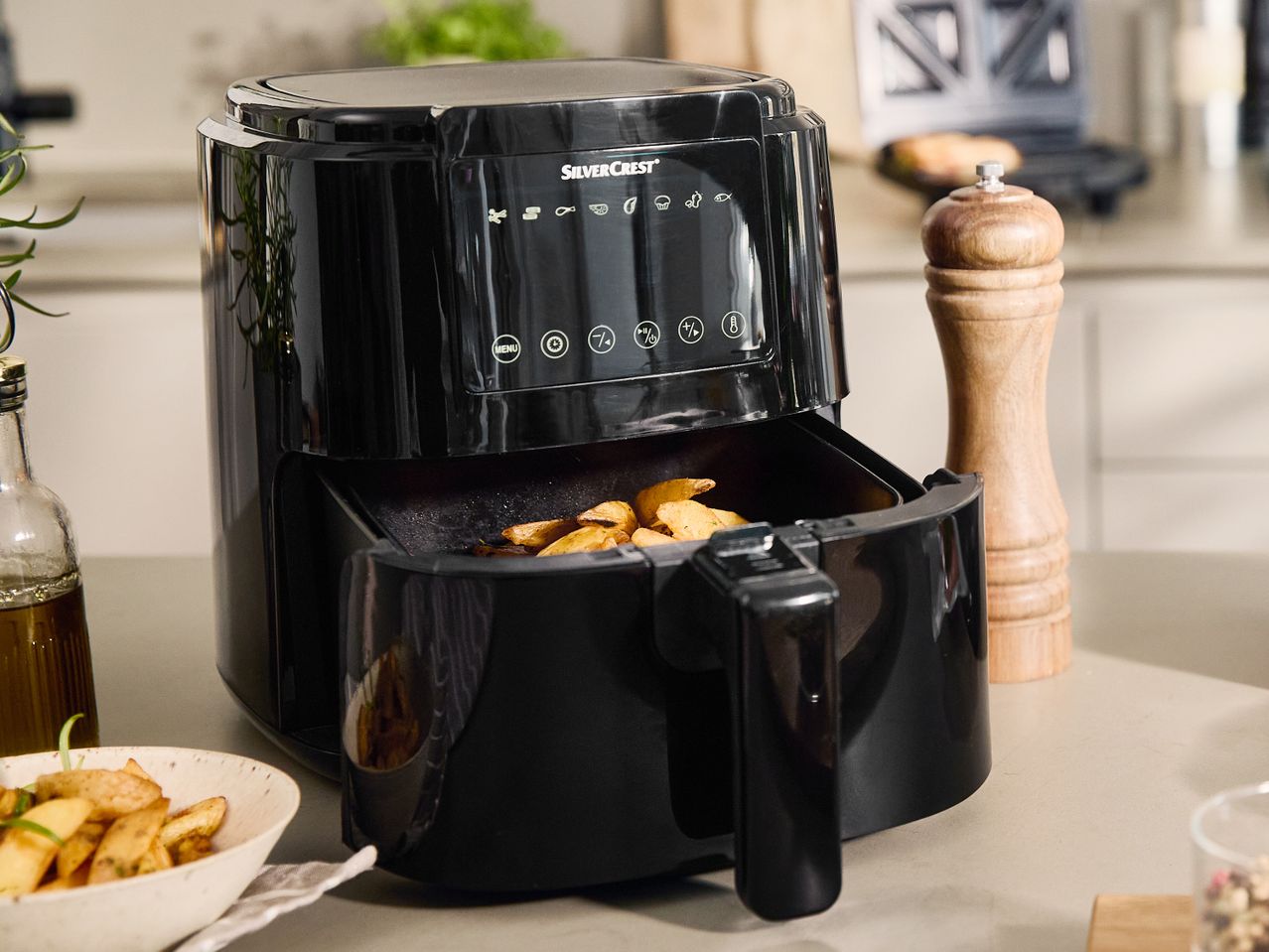Juoda 'Cuisinart' oro gruzdintuvė su keptomis bulvytėmis.