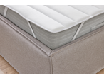 LIVARNO Matratzenauflage: colchão superior branco texturizado com alças numa base de cama bege.