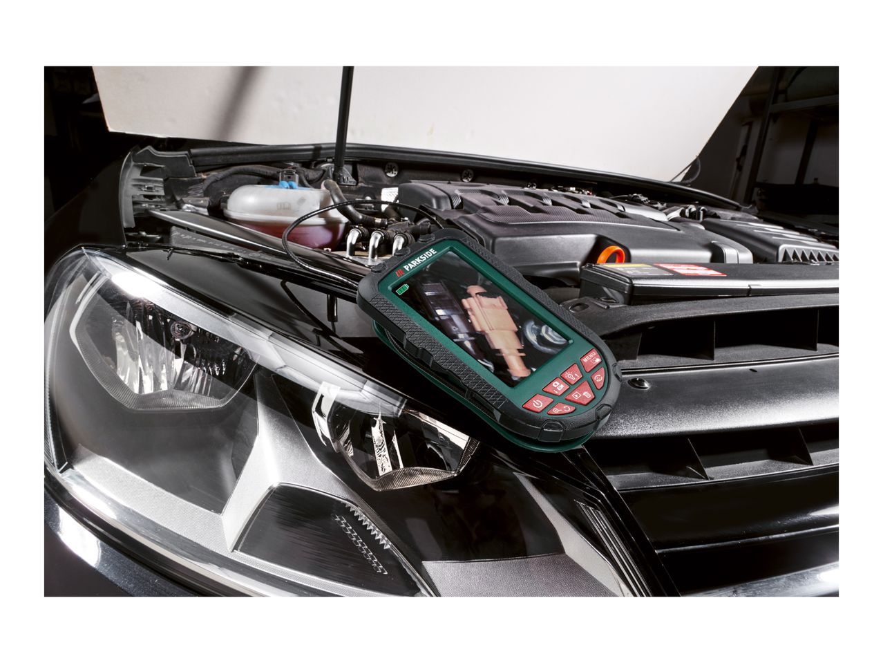 A Parkside inspection camera on a car with its hood open, showing the engine.