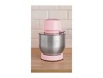 Pink stand mixer with a stainless steel bowl on a wooden counter.