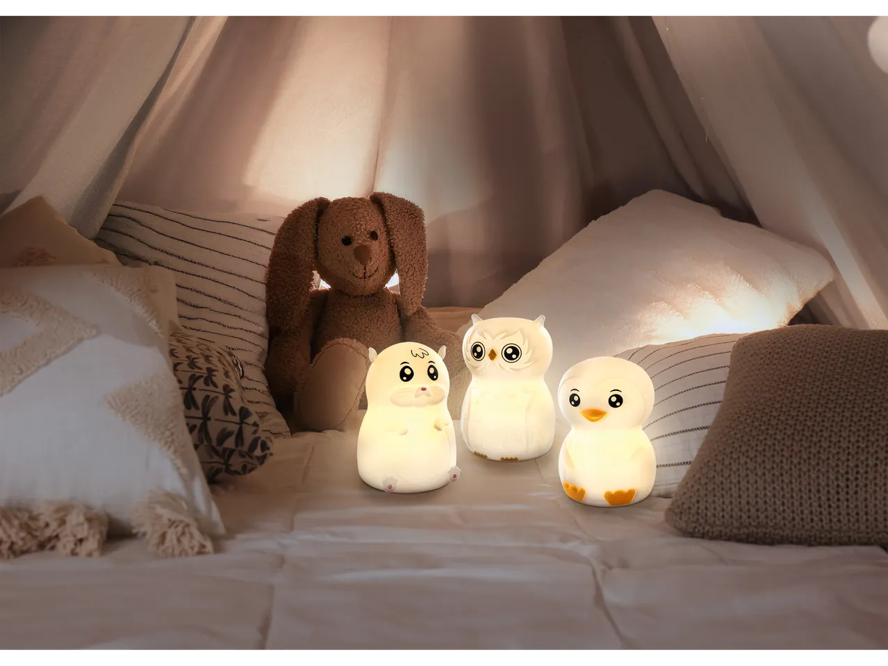 Ansmann wiederaufladbare Silikon-Nachtlichter (Hamster, Eule, Pinguin) und Kuscheltier in einem Zelt.