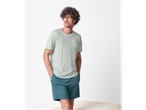 Bărbat cu tricou verde deschis și pantaloni scurți turcoaz.