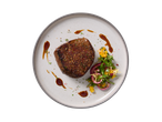 Filete de salmão com salada fresca e molho num prato.