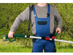 Man in overalls holding a cordless pole pruner with a strap, against a green background.