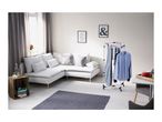 Living room with white corner sofa, wooden crate side table, and clothes drying rack.