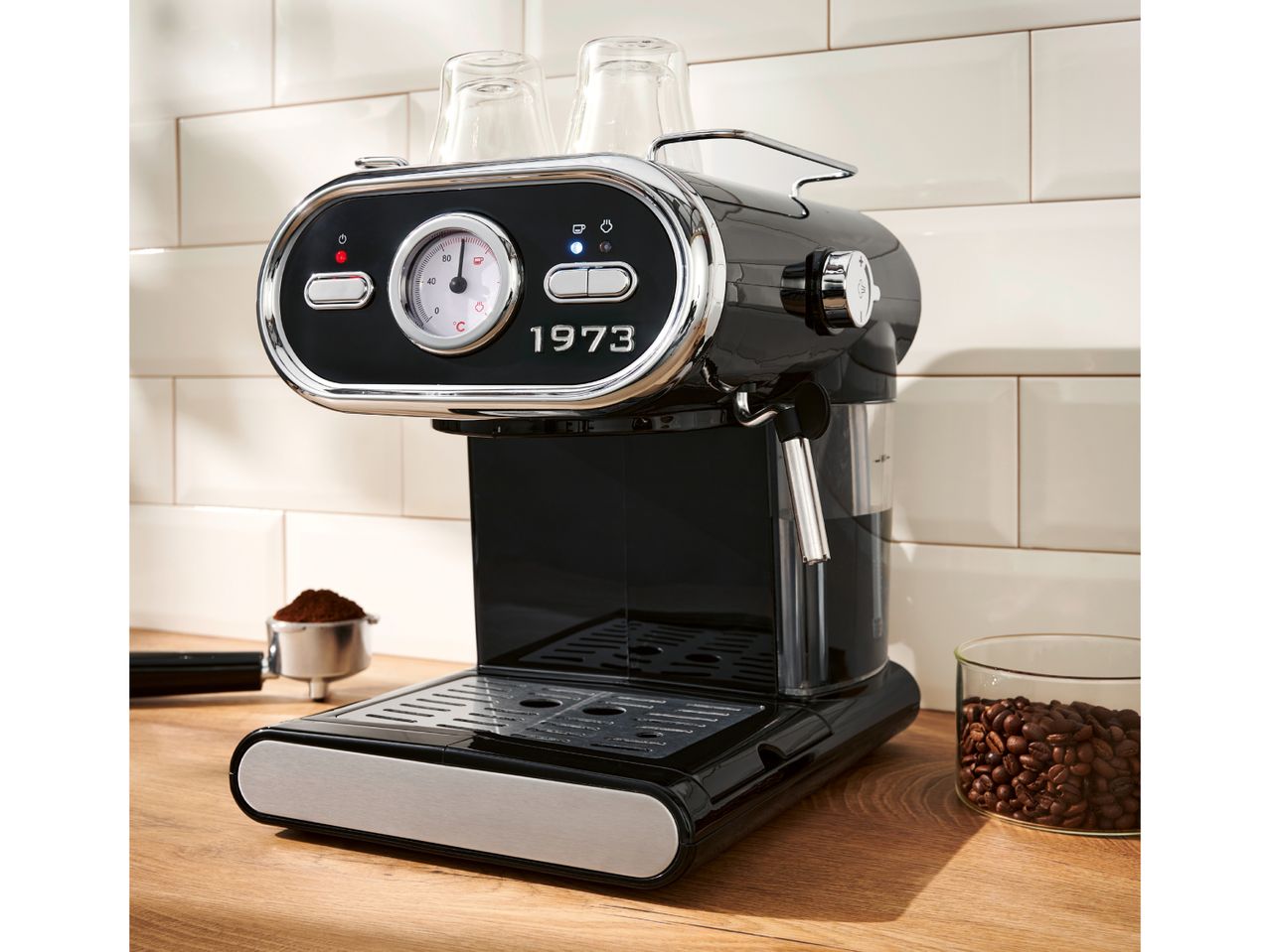 Black and chrome espresso machine with a temperature gauge and coffee beans.