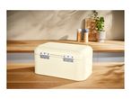 Cream-colored metal bread bin with hinges on a wooden kitchen countertop.