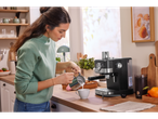 Mulher a fazer café com uma máquina SilverCrest numa cozinha moderna.