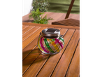 Luminária solar com vidro colorido em mesa de madeira.