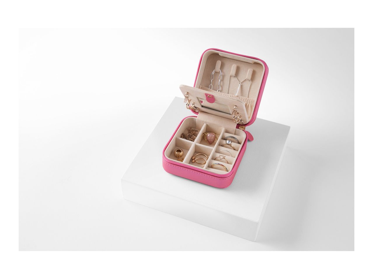 A pink travel jewelry case with compartments for earrings, necklaces, and rings.