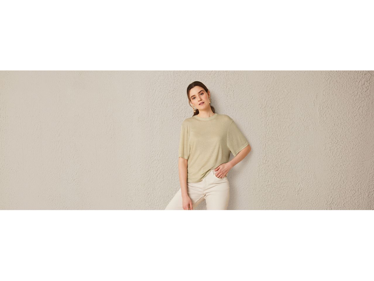 Donna che indossa una maglietta verde chiaro e pantaloni bianchi.