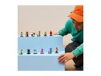A child looking at a collection of diverse minifigures displayed on blue blocks.