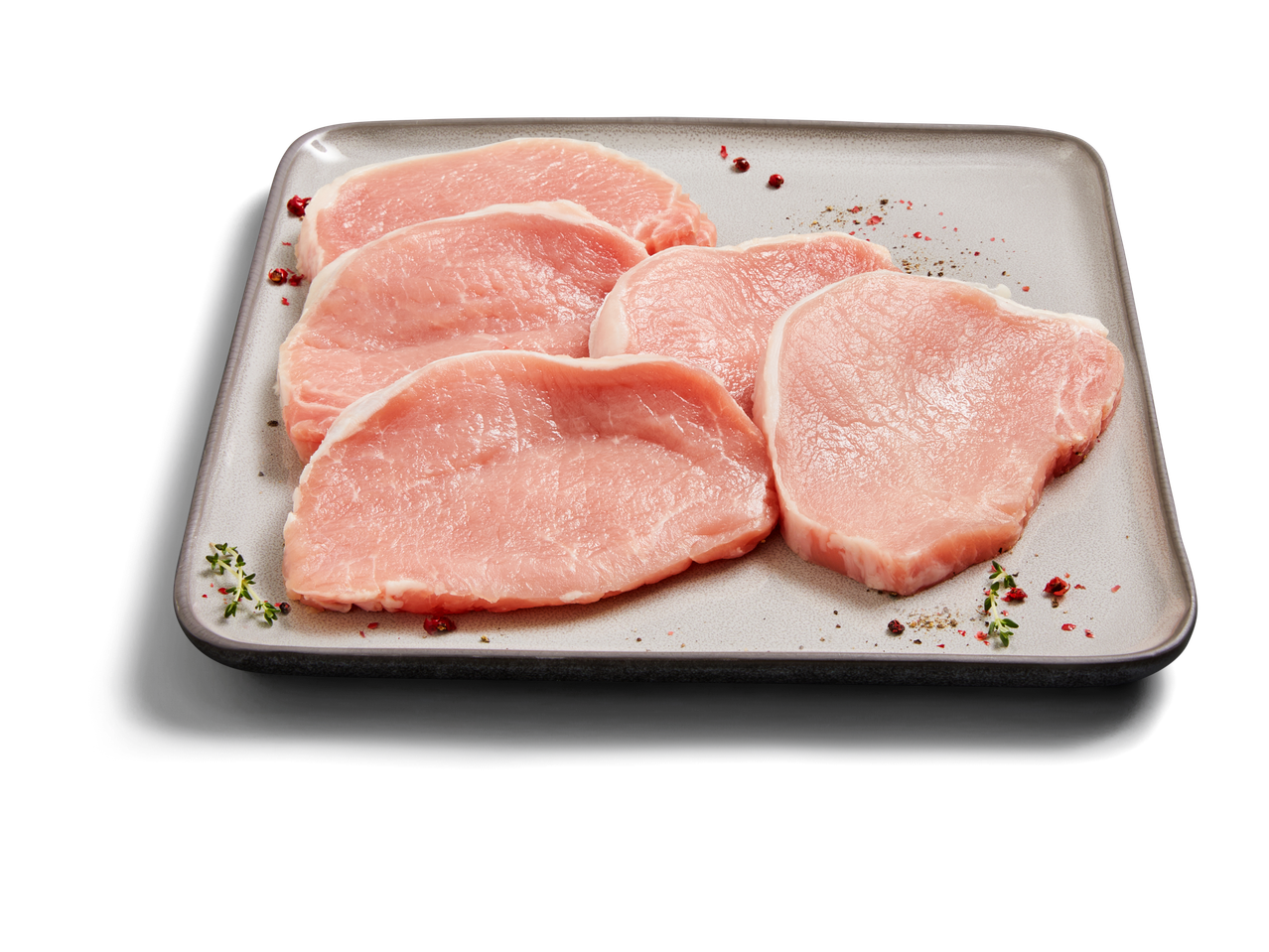 Rohe Schweinekoteletts mit Gewürzen.