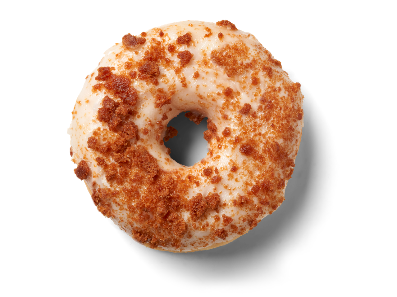 Een enkele donut met wit glazuur en bruine Biscoff koekkruimels op een zwarte achtergrond.