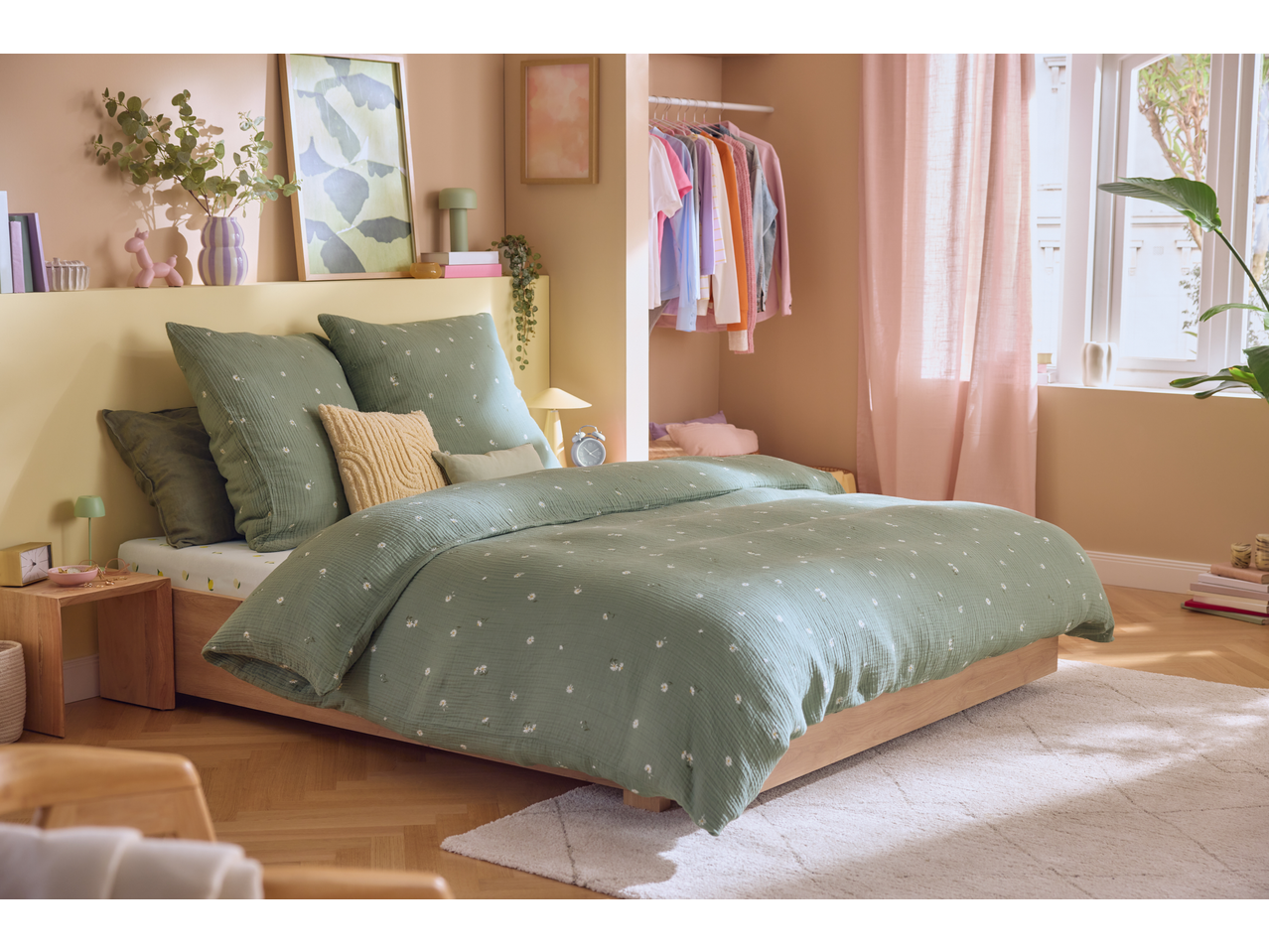 Livarno Premium Muslin Duvet Cover Set in sage green with daisy pattern on a bed in a bright bedroom.