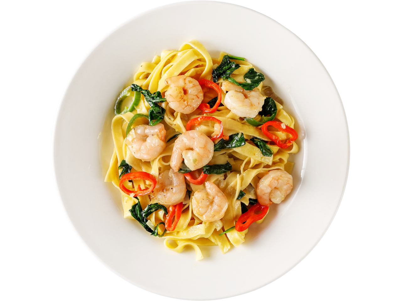 Shrimp pasta with red and green peppers and spinach on a white plate