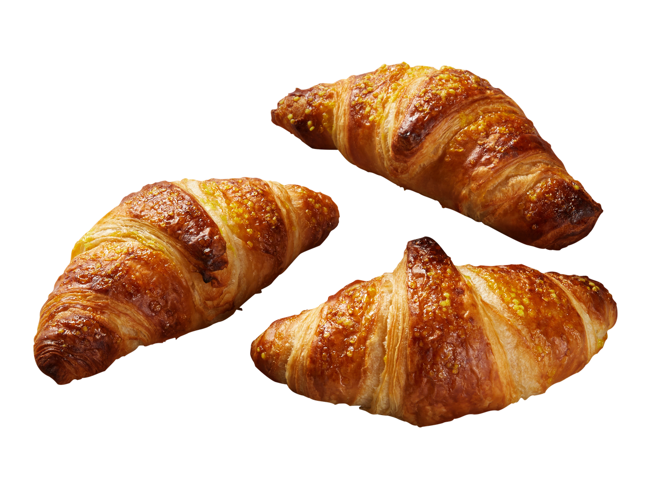 Kolme kullanruskeaa, rapeaa croissantia mustalla taustalla.