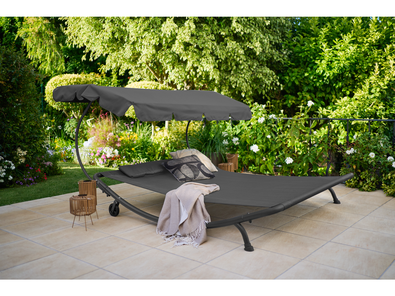 Livarno LED Solar Lanterns on a patio next to a garden daybed with a canopy.