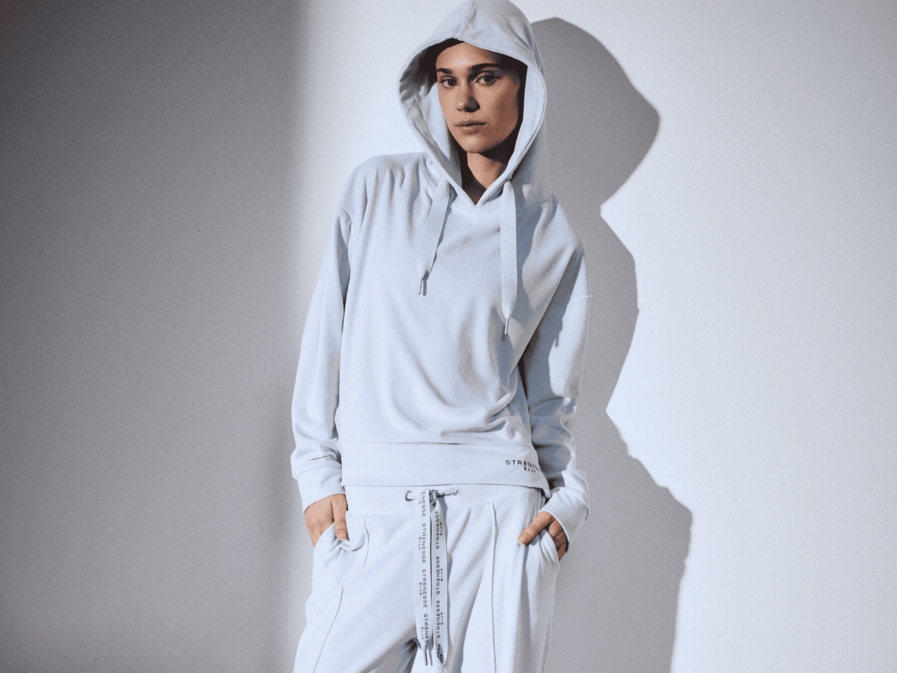 Frau in hellblauem STRENESSE Hoodie und Jogginghose