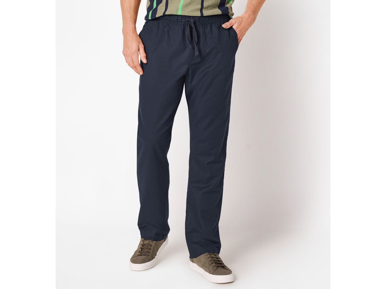 Men's navy blue drawstring trousers with a striped t-shirt and brown sneakers