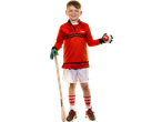 Smiling boy in red top, white shorts, and red socks, holding a hurley and a sliotar.