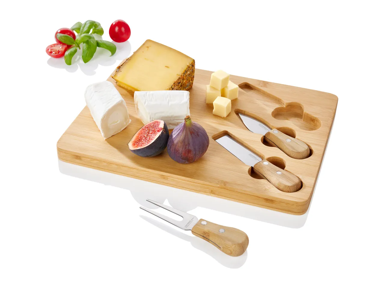 Bamboo cheese board with three cheese knives and assorted cheeses and figs.