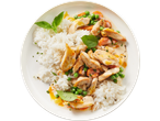 Chicken curry with rice, peas, and carrots, garnished with basil leaves on a white plate.