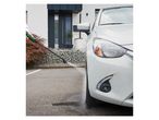 Car wash with pressure washer: cleaning a white car.